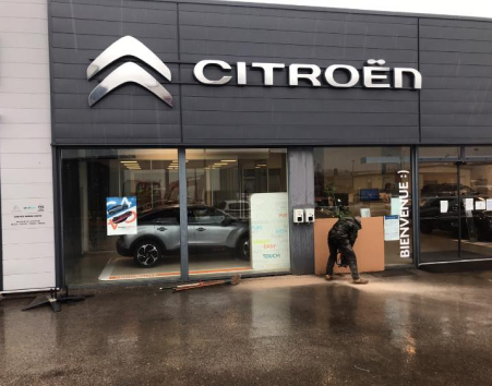 Concessionnaire Citroën, ouvrier travaillant sous la pluie.